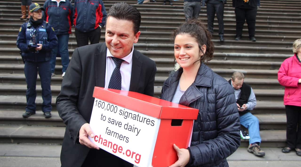 Chloe Scott with Nick Xenophon. She holds a box reading '160,000 signatures to save dairy farmers'