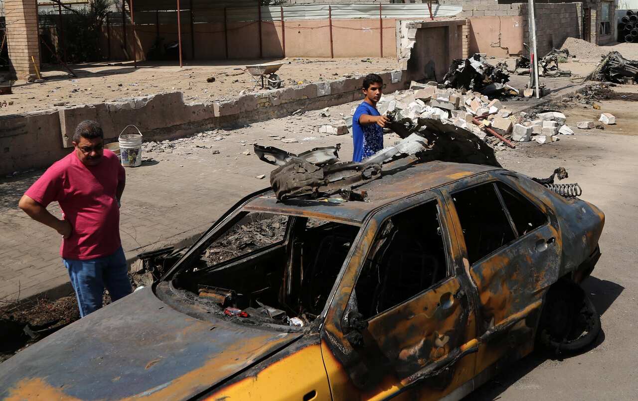 People inspect the scene of after an explosion