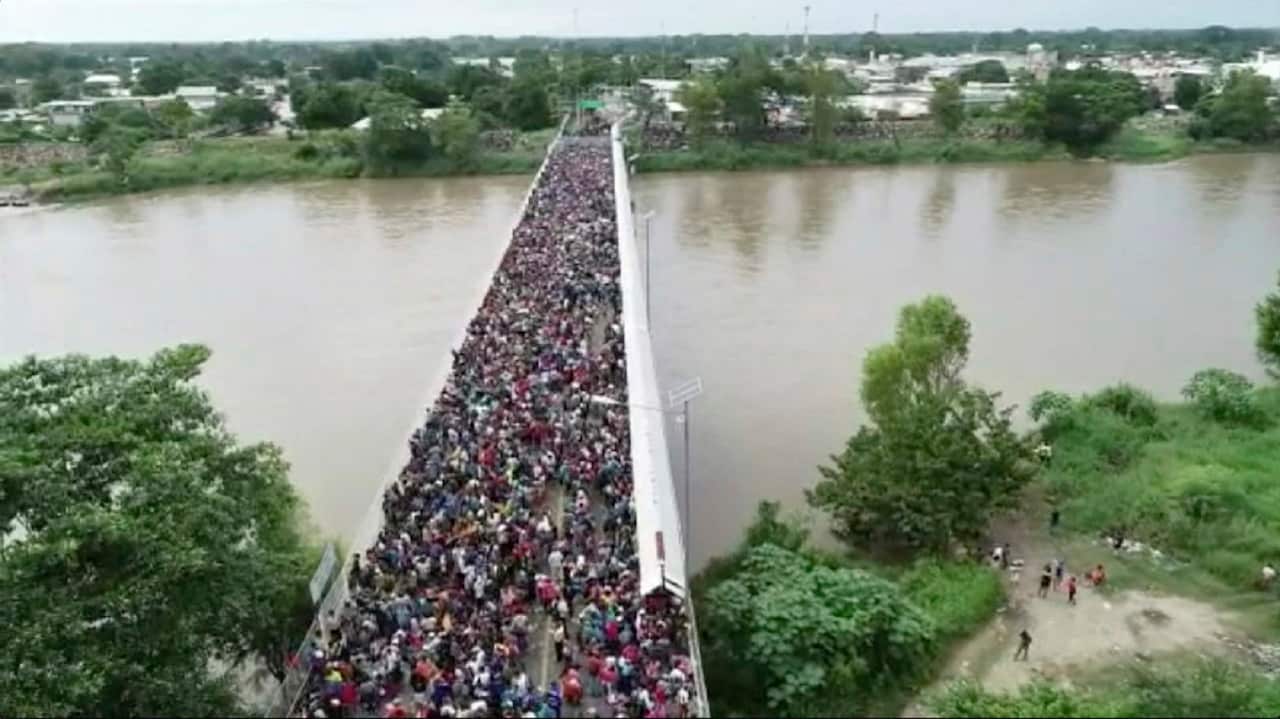 Migrants bound for the US.-Mexico border wait on a bridge that stretches over the Suchiate River that connects Guatemala and Mexico.