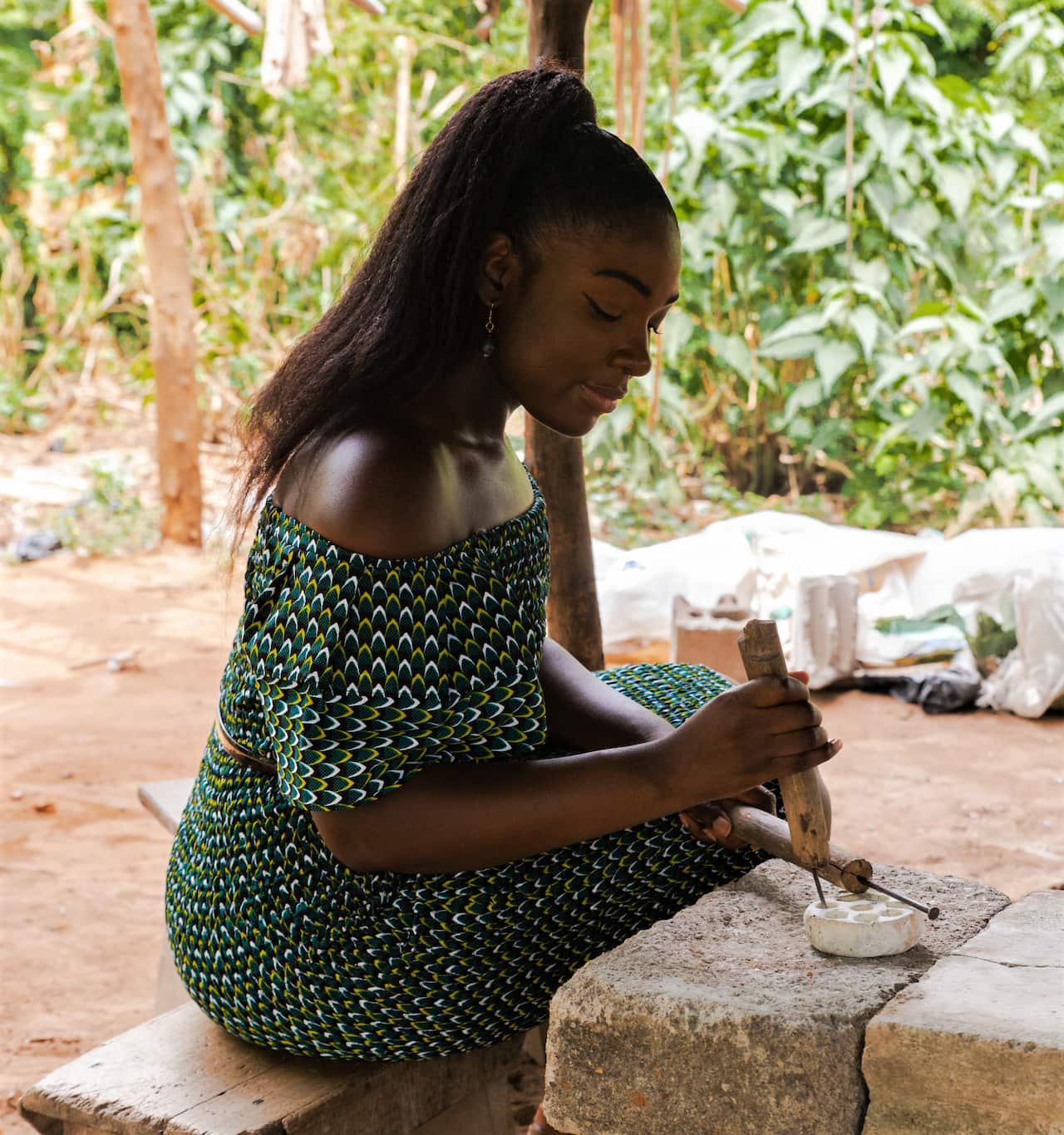 Caroline in Ghana extracting beads from a mould.