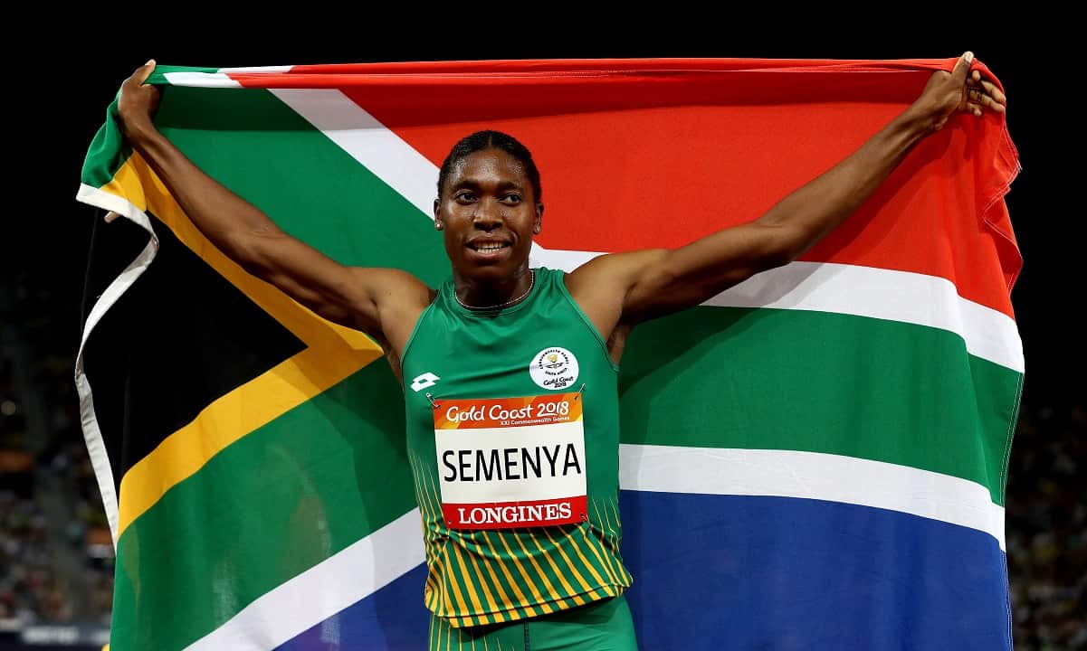 Caster Semenya holds a South African flag over her shoulders after a race 