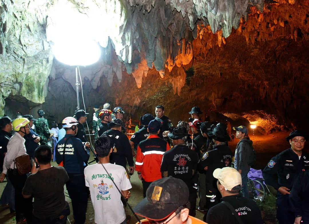 Thai rescue workers and associated officials plan a rescue operation for 12 football players and their coach outside the Tham Luang cave.