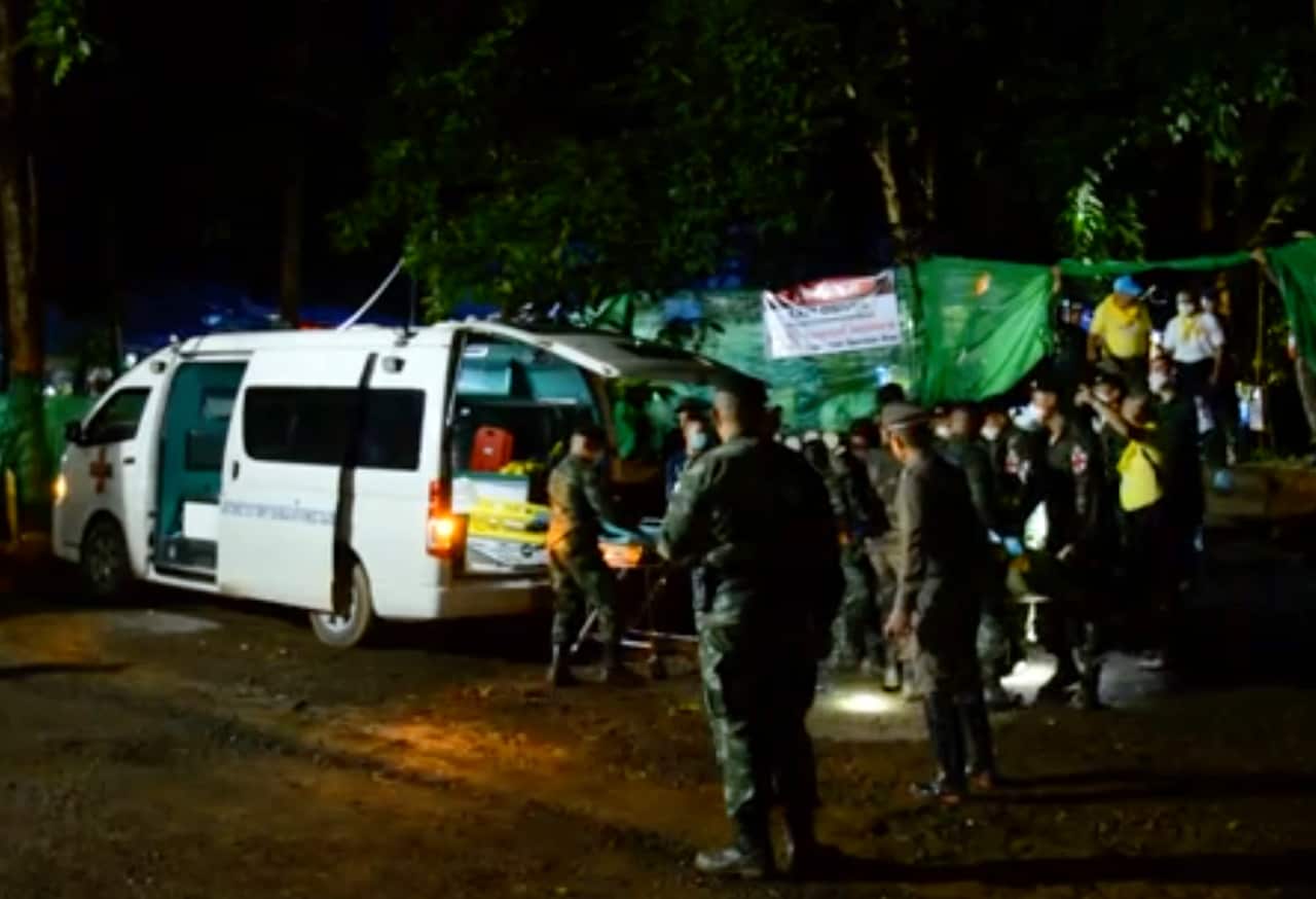 Emergency workers carry a stretcher with one of the rescued boy to be transported by ambulance.