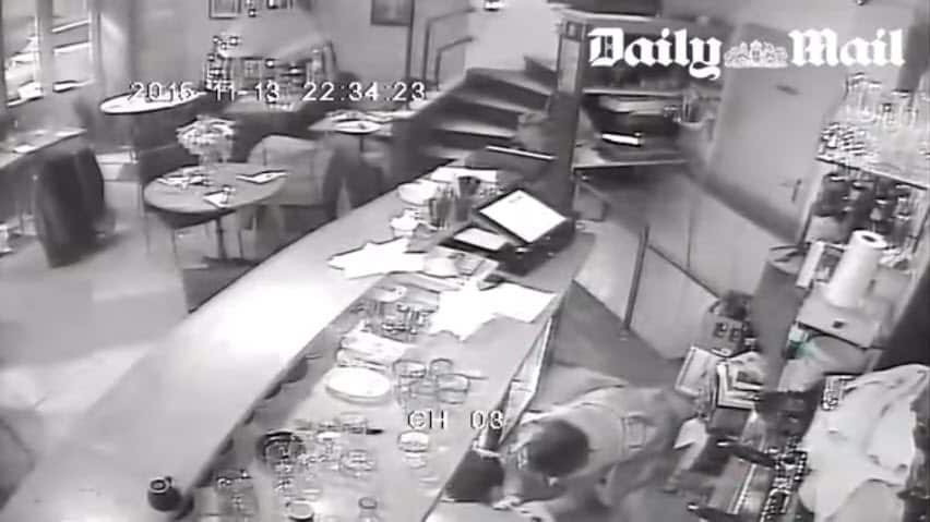 A young comforts a woman who appears to be injured during an attack on a Paris restaurant.