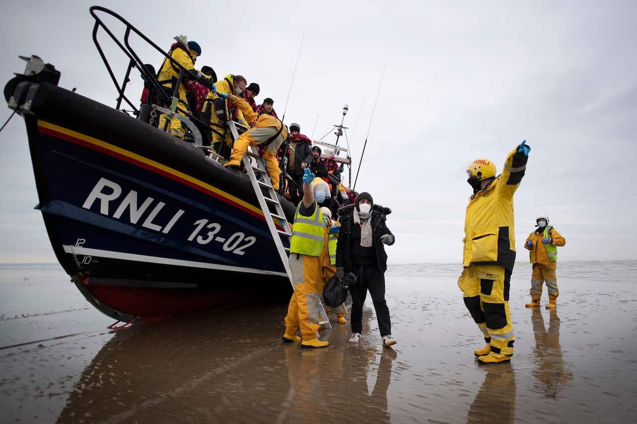 Migrants are helped ashore after being rescued by a royal national lifeboat on the southeast coast of England.