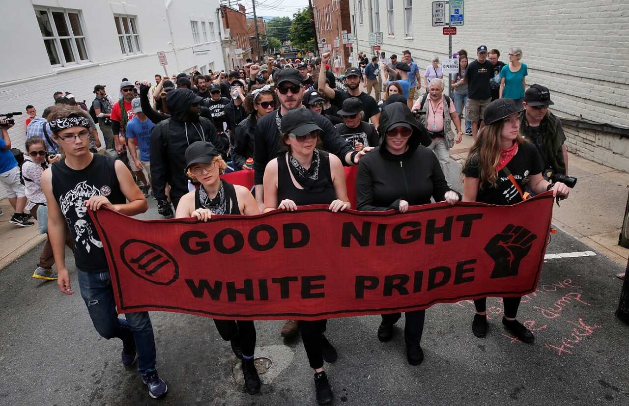  A group of protesters known as 'Antifa', or anti-fascists, march near ths site of a makeshift memorial where Heather Heyer was killed 