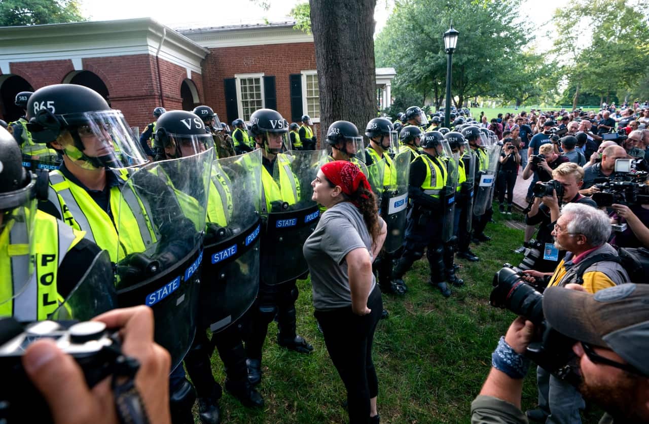 State police form a line as students from the University of Virginia (UVA), along with residents and anti-fascists, march across the UVA campus 