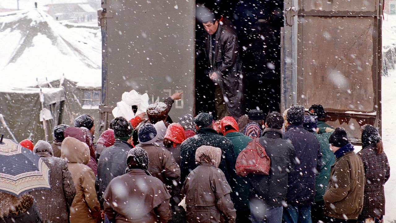 Chechen refugees queue for humanitarian aid in freezing conditions in November 1999.