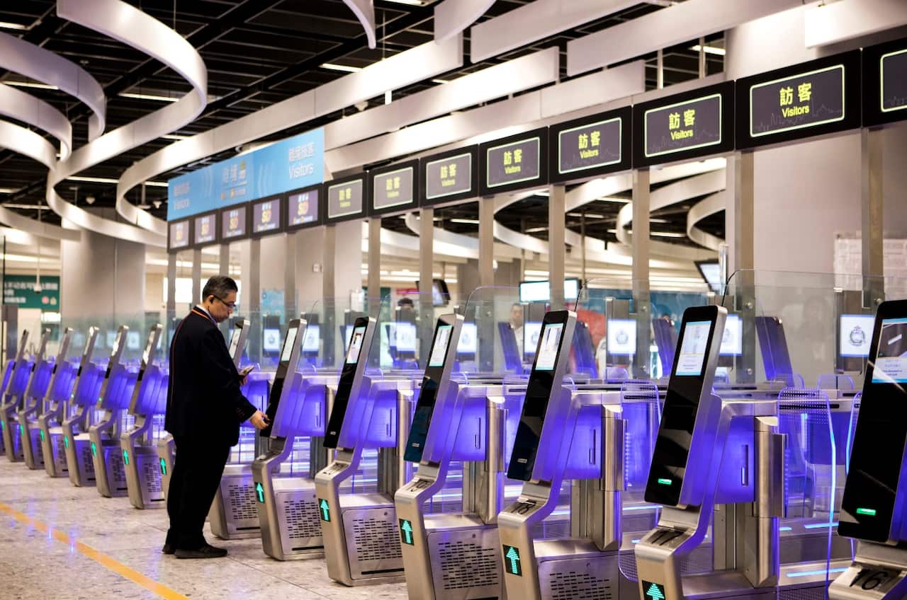 A man uses an automated immigration clearance machine for departing passengers in the Hong Kong Port Area at West Kowloon Station