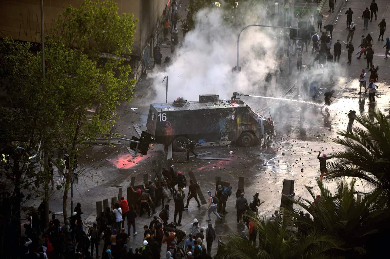 An armoured vehicle sprays protesters with a water cannon during the demonstrations.