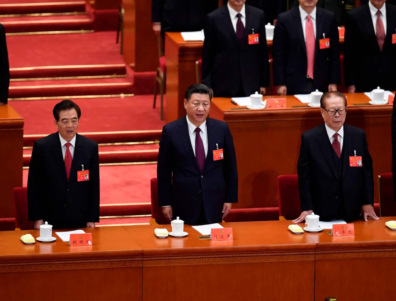 Xi Jinping (C) sings the National Anthem with former presidents Jiang Zemin (R) and Hu Jintao (L) during the opening of the 19th Communist Party Congress