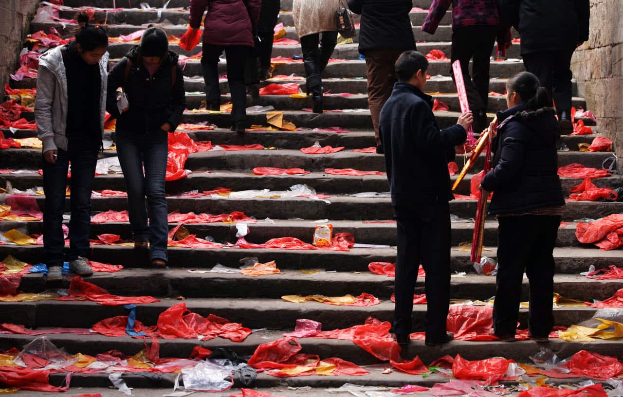 Pilgrims walk on plastic bags which are used to pack incense, candles and joss papers at a temple on February 7, 2008 in Chongqing Municipality, China.