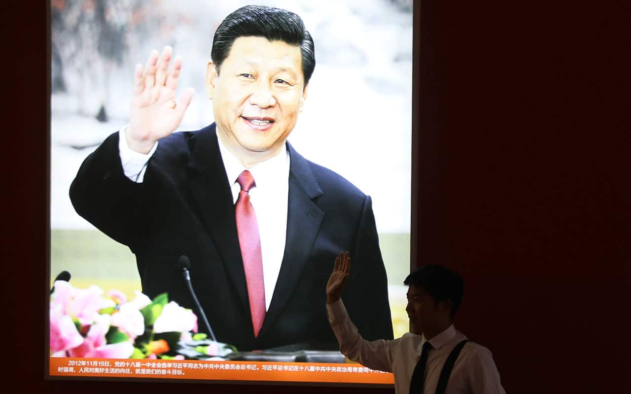 A visitor poses for a photo at a Beijing exhibition of China's outstanding achievements