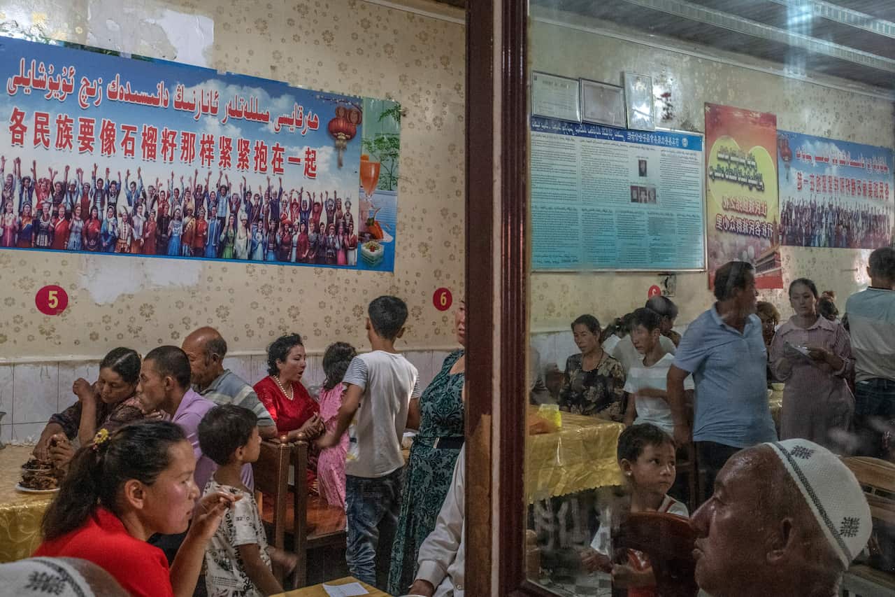 Patrons dine under posters quoting Xi Jinping, reading every ethnic group must tightly bind together like the seeds of a pomegranate, at a restaurant in Yarkand, in Chinas Xinjiang province, Aug. 5, 2019. (Gilles Sabri/The New York Times)
