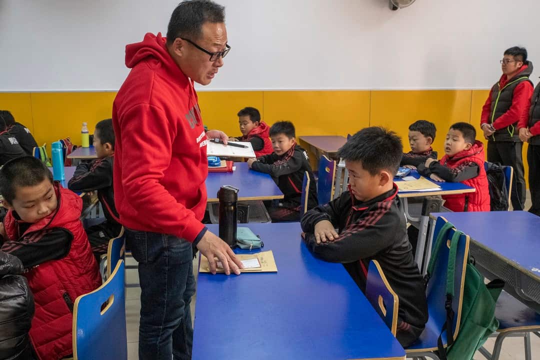 Tang Haiyan, founder of the Real Boys Club, lectures a student in Beijing.