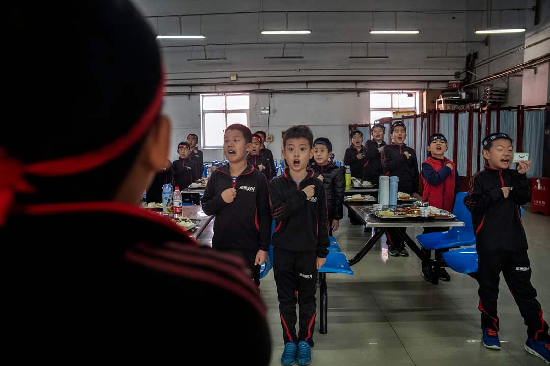 Students at the Real Boys Club recite the club's pledge in Beijing.