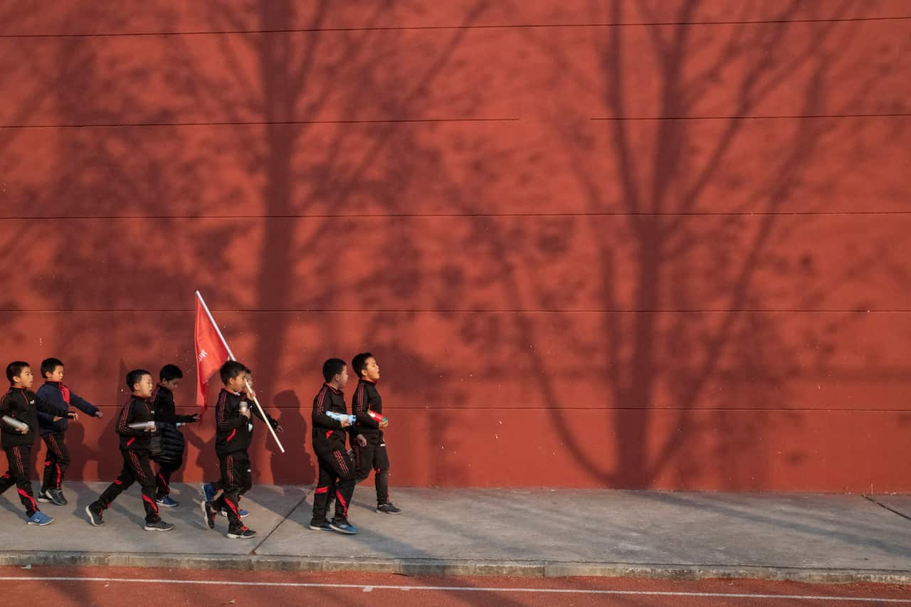 Students at the Real Boys Club chant while walking to the bus at the end of their training in Beijing.