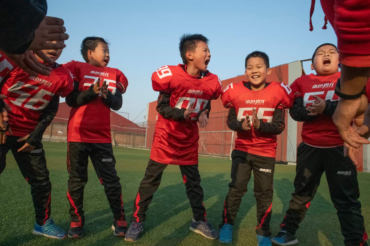 Students at the Real Boys Club shout the club's pledge at the end of football practice in Beijing.