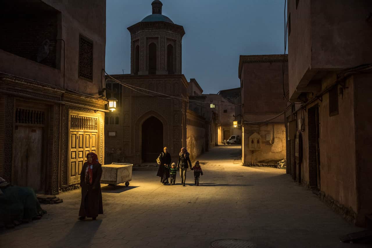 Pedestrians walk past a mosque in Kashgar, China.