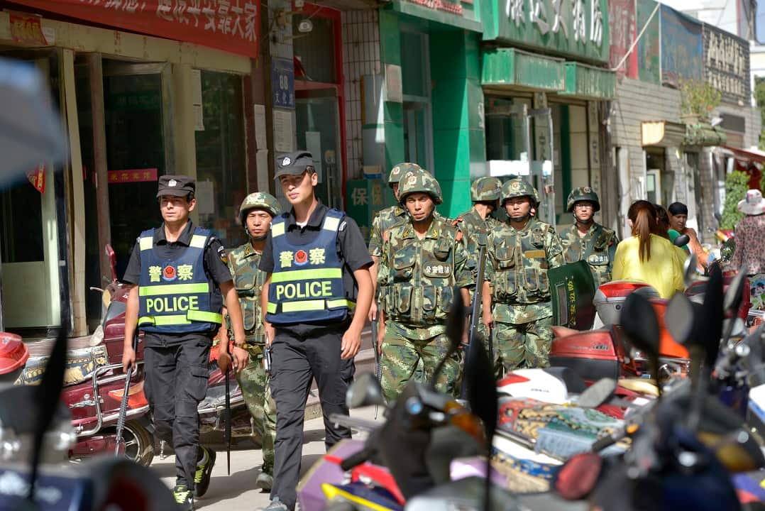 Chinese police officers and paramilitary policemen patrol a street in Kashgar city in Xinjiang Uygur Autonomous Region.