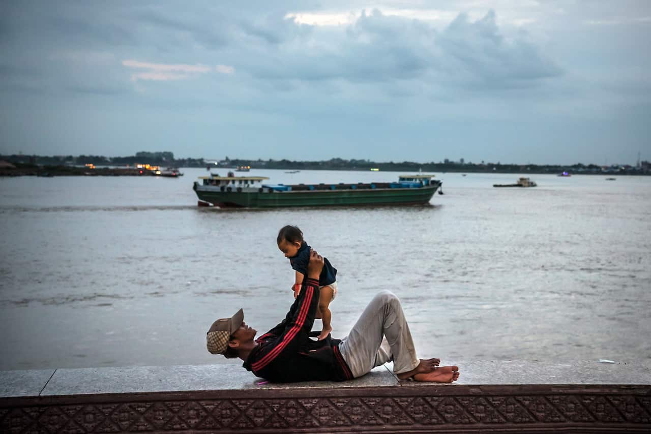 A father and son along the Mekong River in Phnom Penh, Cambodia.