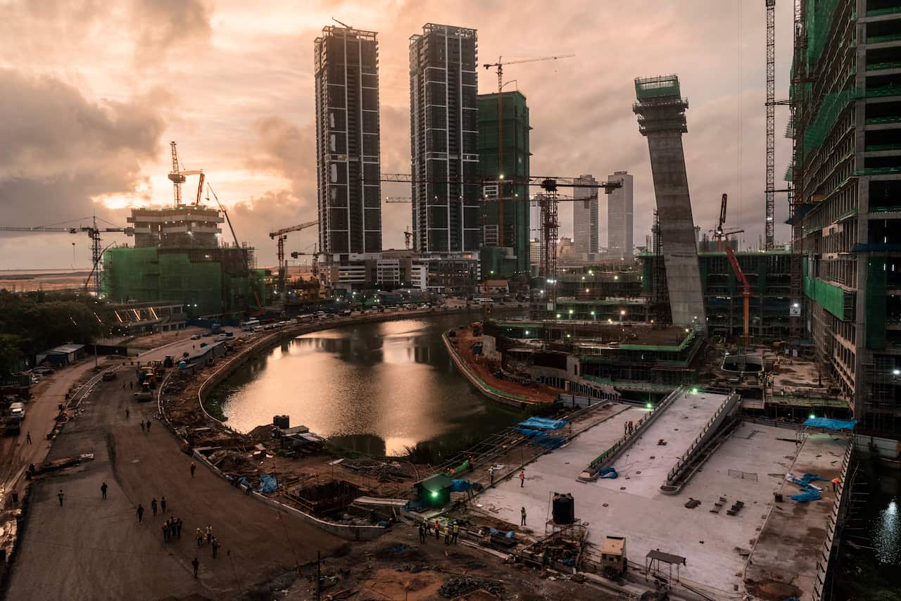 Chinese construction workers, bottom left, walk home from their jobs in Colombo, Sri Lanka, June 4, 2018.