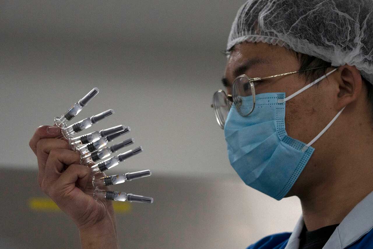 A worker manually inspects syringes of SARS CoV-2 Vaccine for COVID-19 produced by SinoVac at its factory in Beijing.
