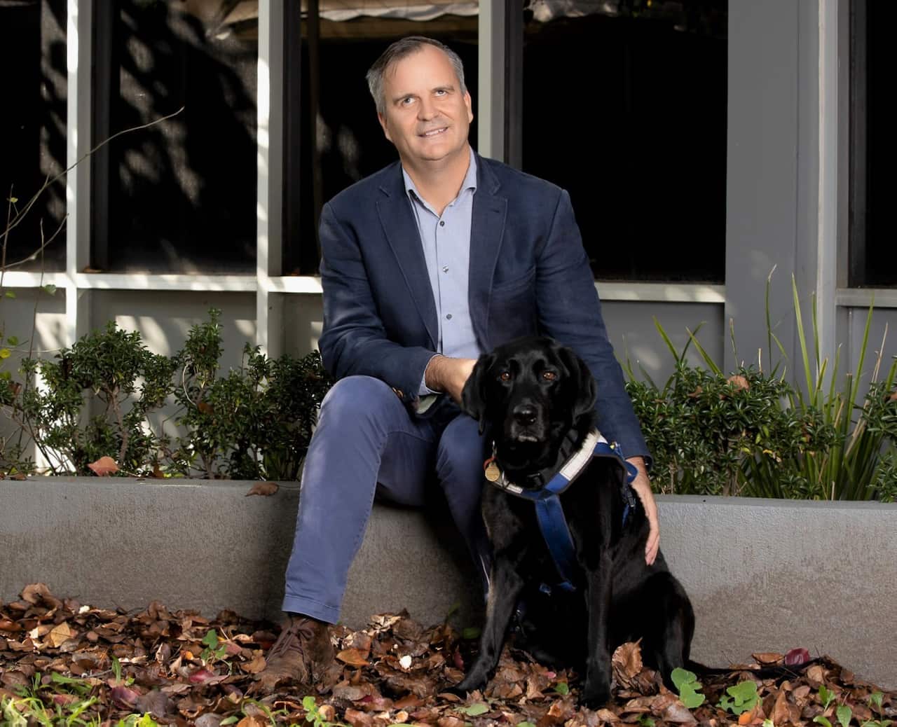 Vision Australia's Chris Edwards with his dog, Odie.