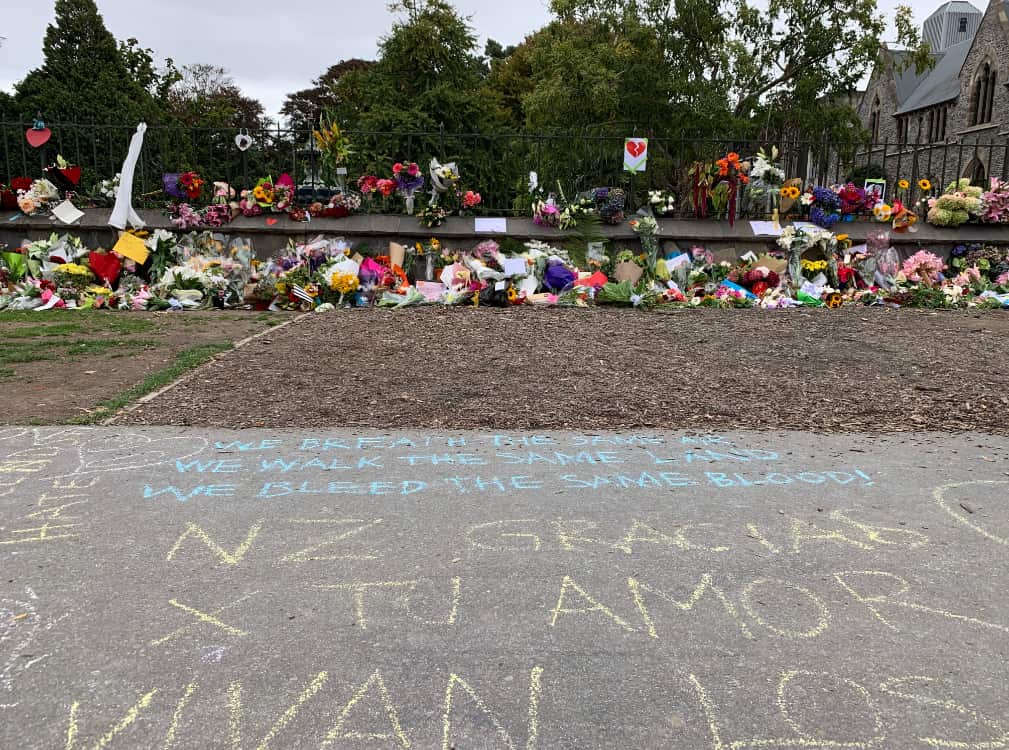 Mourners write messages in chalk along the footpaths in Christchurch.