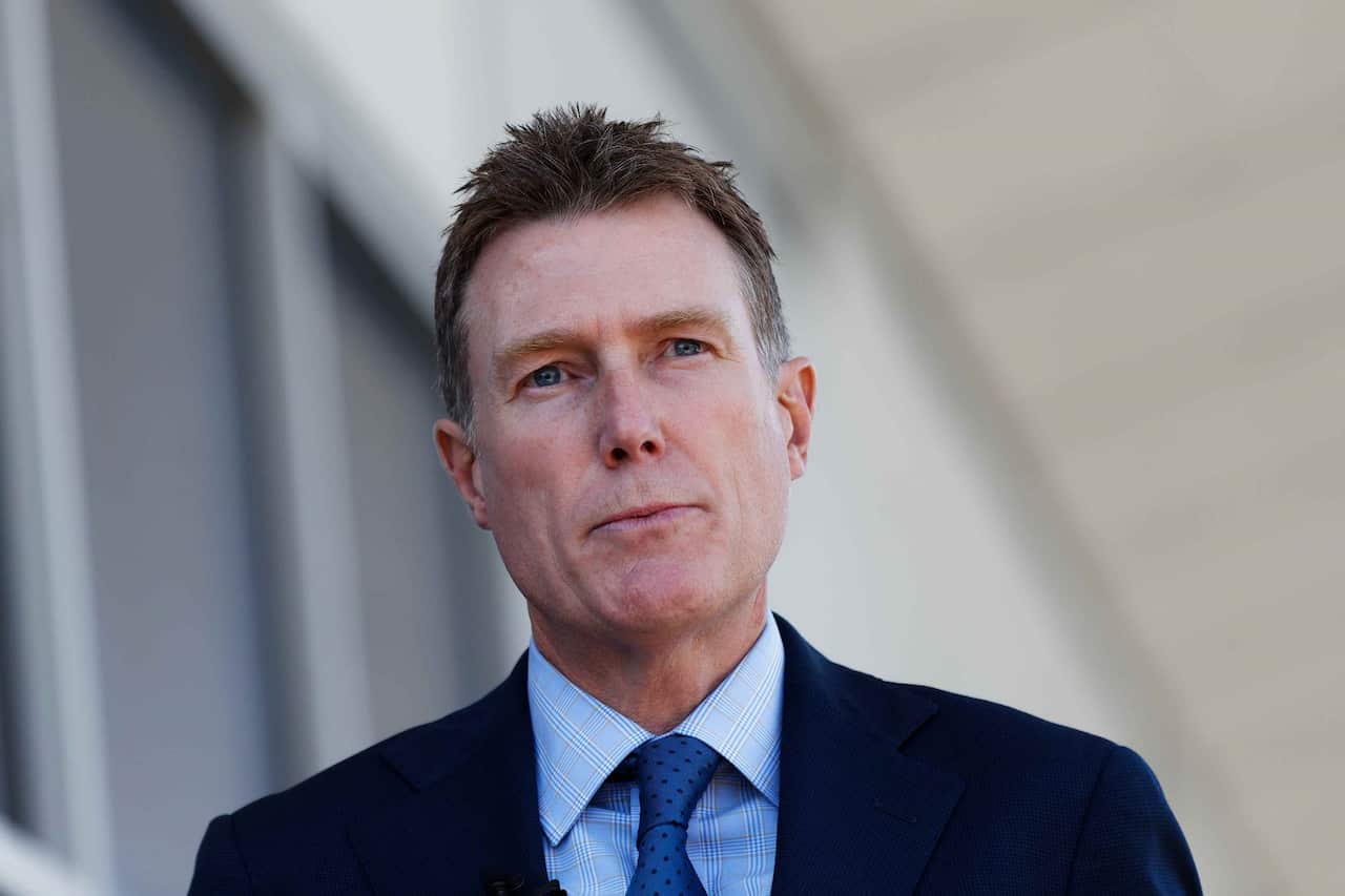 一個穿著西裝打著領帶的男人站在外面。