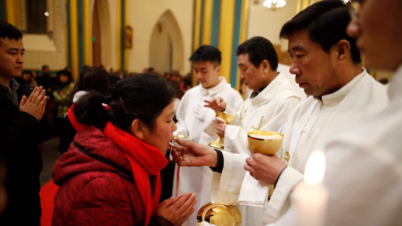 Catholics receive the Eucharist during he Christmas Eve mass in the Xishiku Catholic Church in Beijing, China, 25 December 2018.