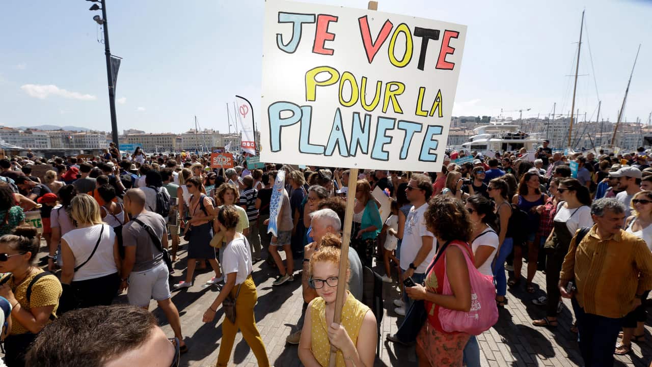 A person holds a placard reading "I vote for the planet", during a demonstration for the climate, in Marseille, southern France.