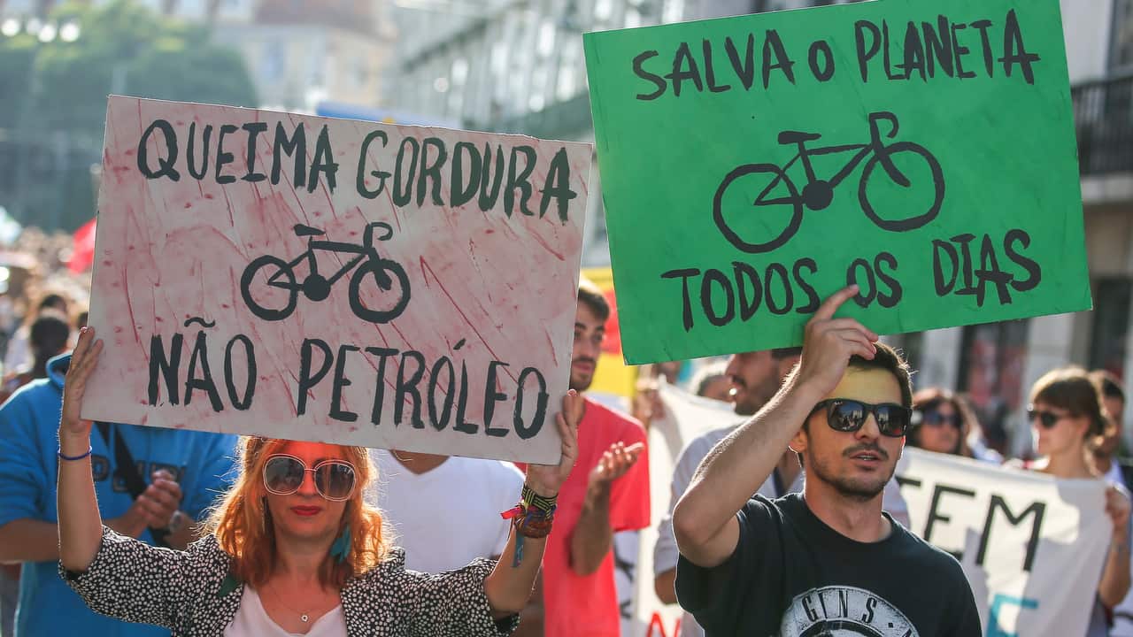 Protestors hold signs saying 'Burn Fat, Not Oil' and 'Save the Planet Everyday' during the 'March for the climate', Lisbon, Portugal.