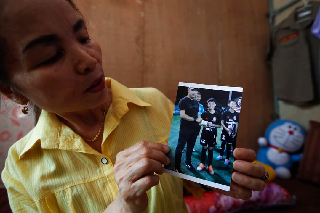 Grandmother Kham-aoey Promthep, 64, shows a photograph of her grandson, Duangpetch Promthep.