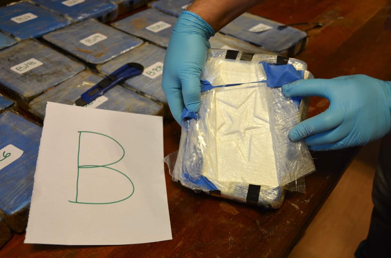 Image released on Feb. 22, 2018 by the Argentine Security Ministry, a police officer shows a package of cocaine that with a star sign