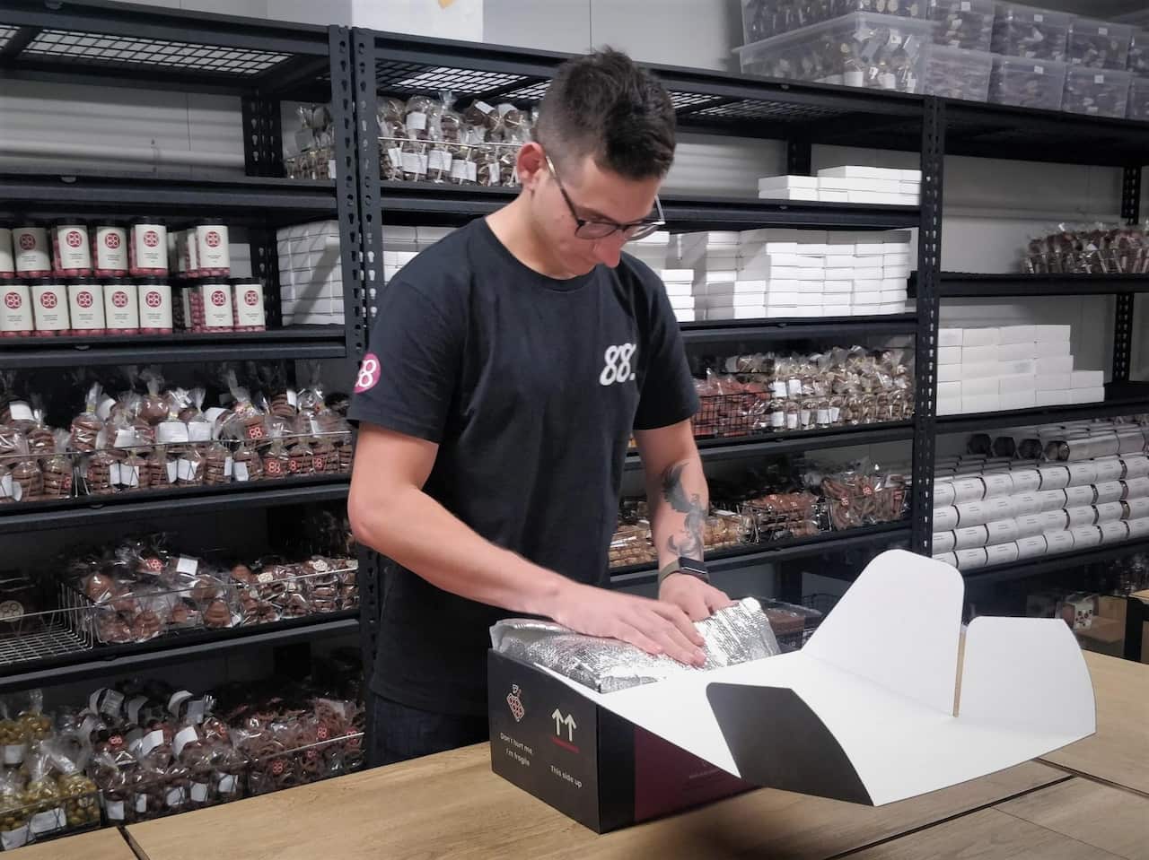 Chris packing chocolates to fill online orders.