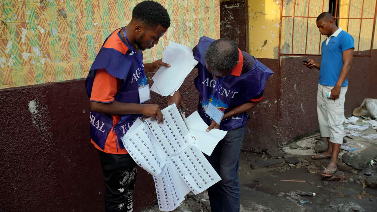 Election officials check the voter's registrations lists just brought in at the Les Anges primary school in Kinshasa, Congo.