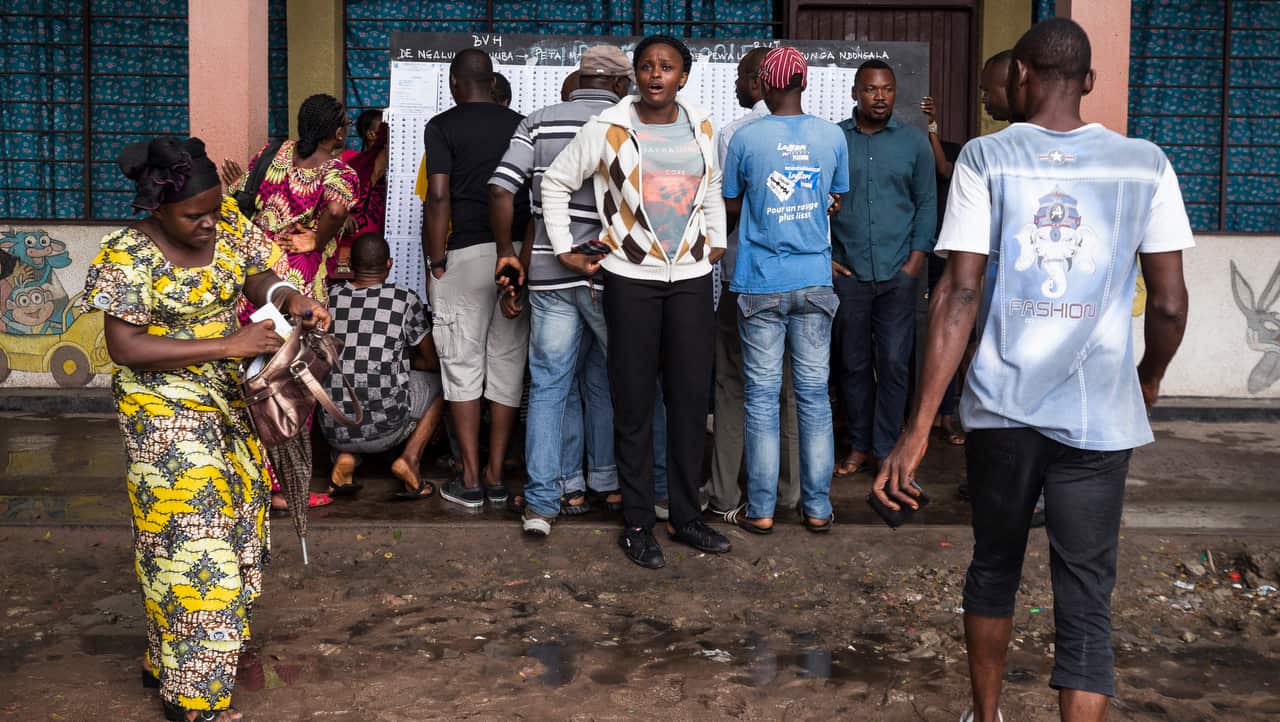 People look for their names on voters' lists at a polling station in Kinshasa, Democratic Republic of the Congo, 30 December 2018.