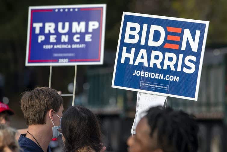 Voters hold signs ahead of the US presidential election.
