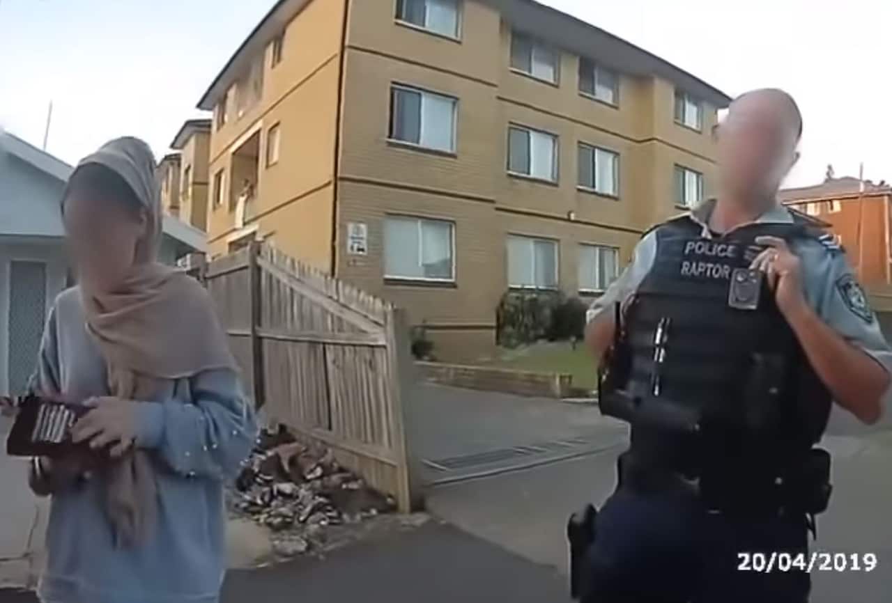 One of the officers speaks with the women. 