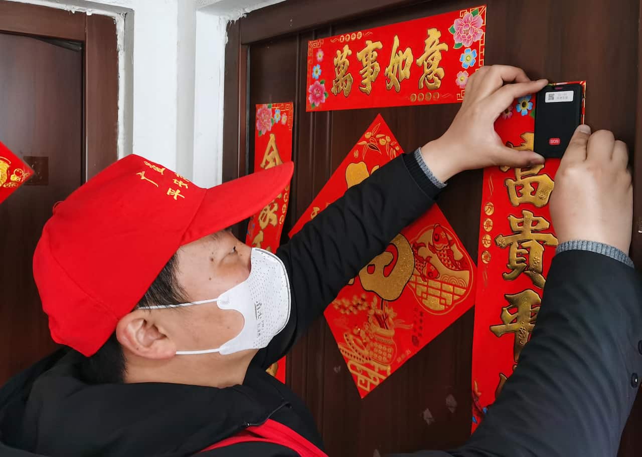 Workers installing an e-seal to monitor suspected novel coronavirus pneumonia patients under isolation in Wuxi, China.