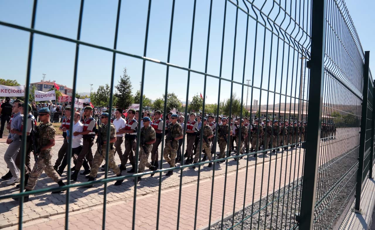 Paramilitary police and special force members escort outside the courthouse as the trial of 486 suspects, including a number of generals and F-16 pilots (AAP)