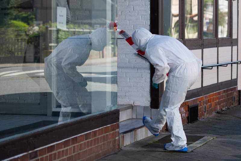 A forensic officer outside the apartment building in northern Germany, where the two fresh bodies were found. 