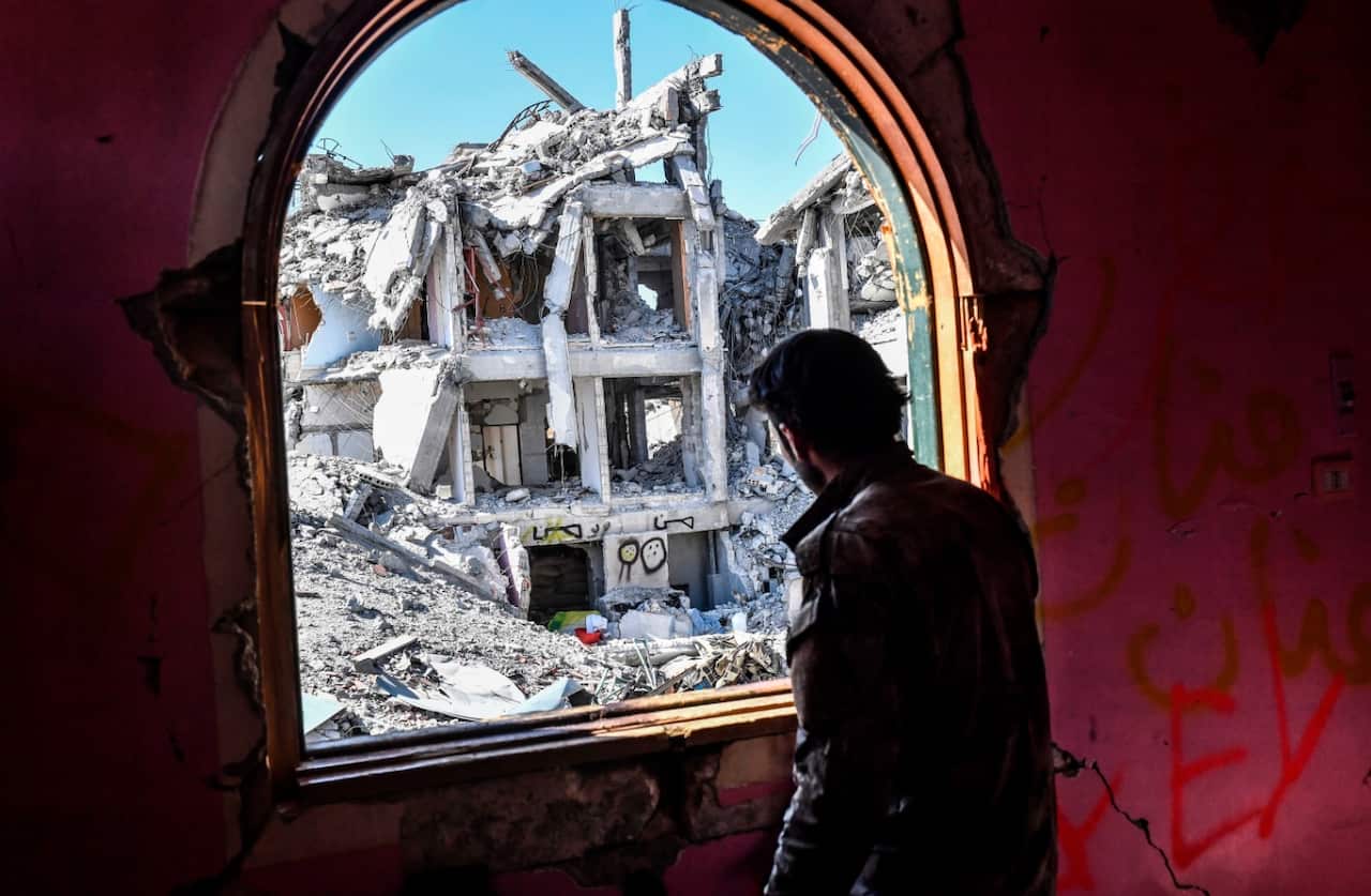A member of the Syrian Democratic Forces (SDF), backed by US special forces, looks out from a building at the frontline (Getty)