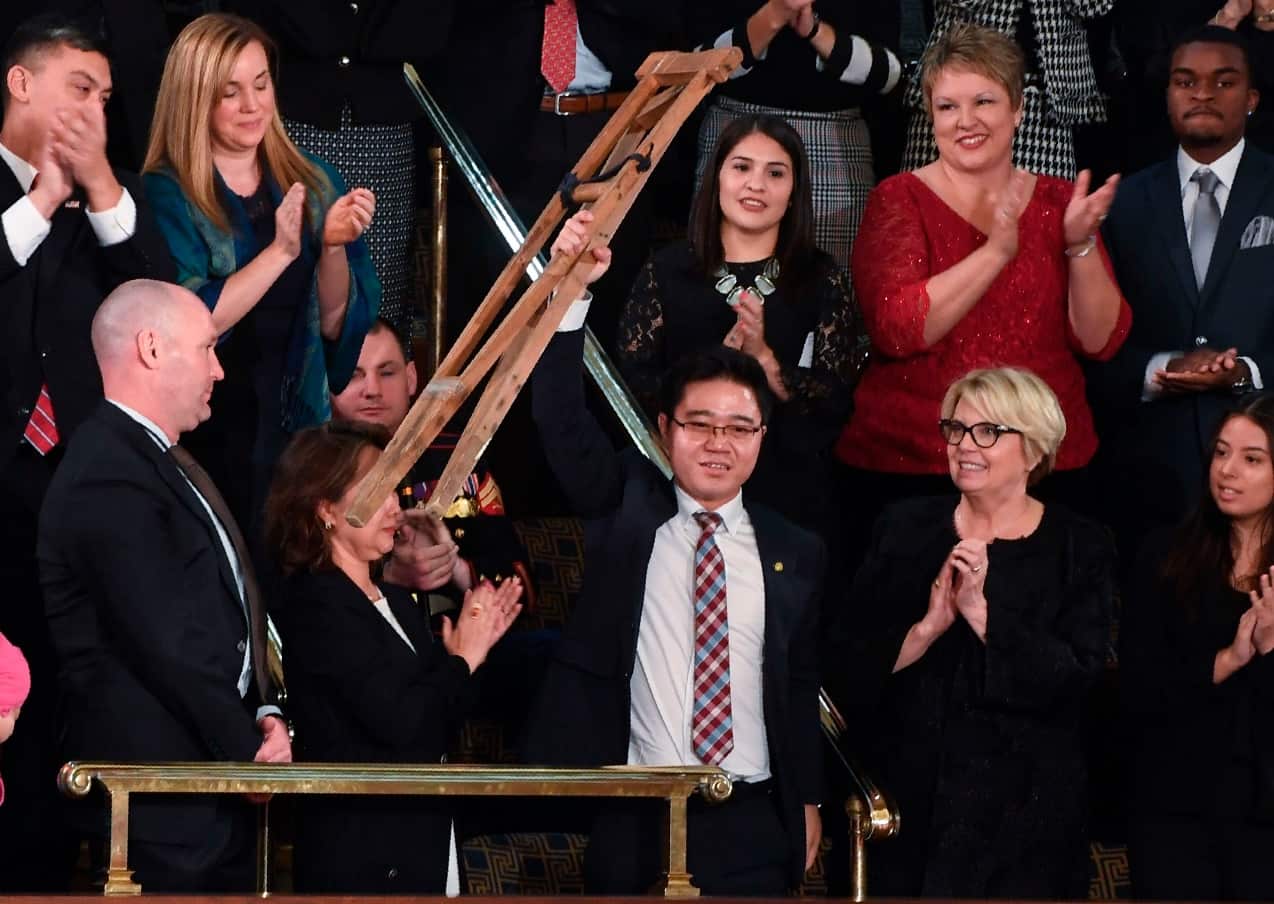 orth Korean defector Ji Seong-ho raises his crutches as US President Donald Trump delivers the State of the Union address at the US Capitol in Washington, DC, on January 30, 2018.