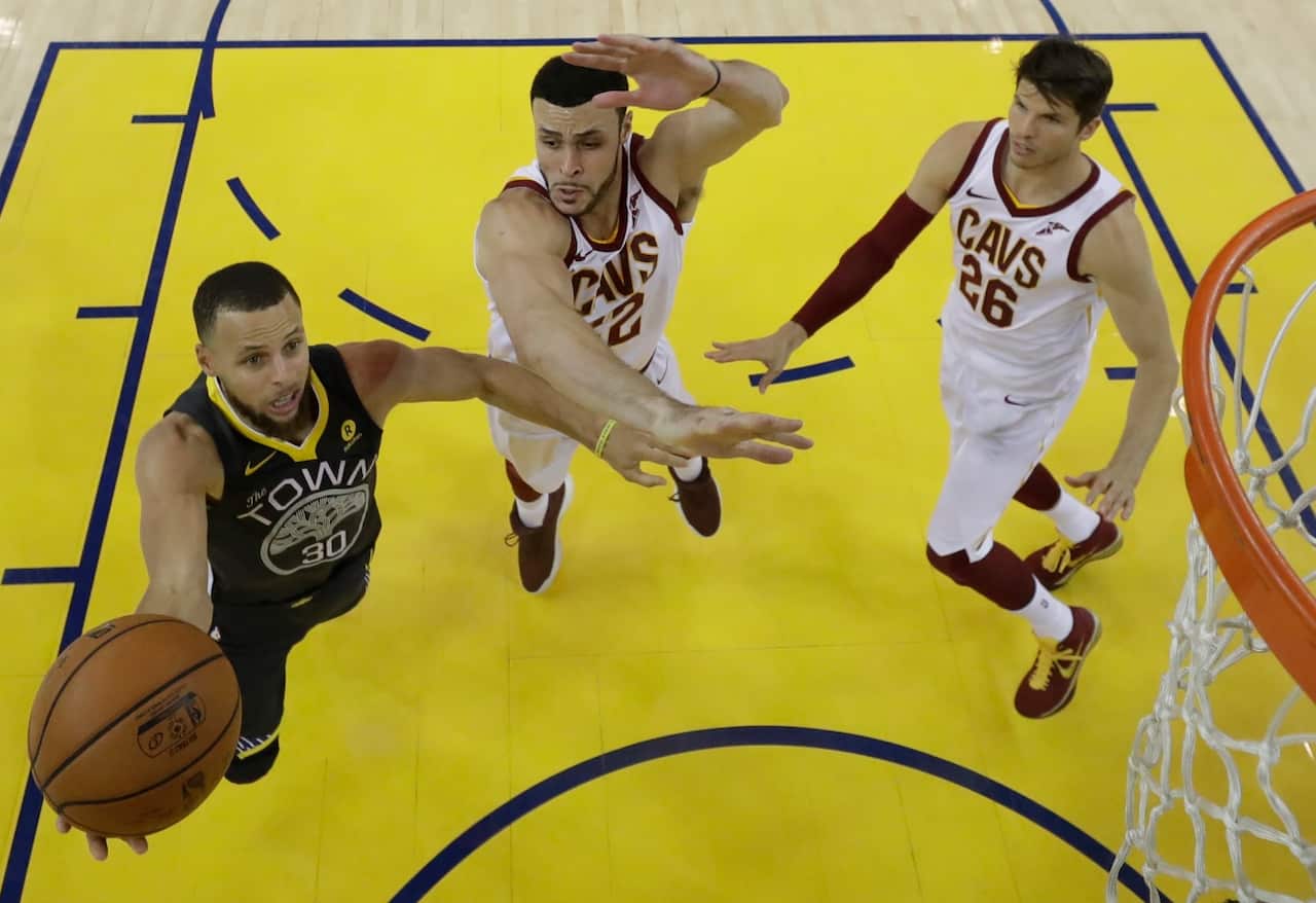 Golden State Warriors player Stephen Curry (L) goes to the basket against Cleveland Cavaliers player Larry Nance Jr. (R)