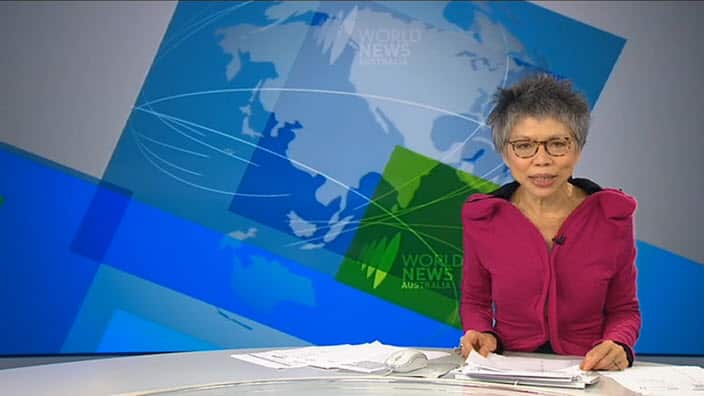 Lee Lin Chin behind the desk.