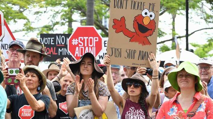 Protestors are seen during a Stop Adani rally in Brisbane, Monday, April 22, 2019. Conservationist and former Greens leader Bob Brown has led a march on the Adani HQ to protest their proposed mine in the Galilee Basin. (AAP Image/Dave Hunt) NO ARCHIVING