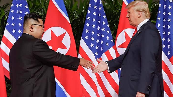 President Donald Trump reaches to shake hands with North Korea leader Kim Jong Un during their Singapore summit.