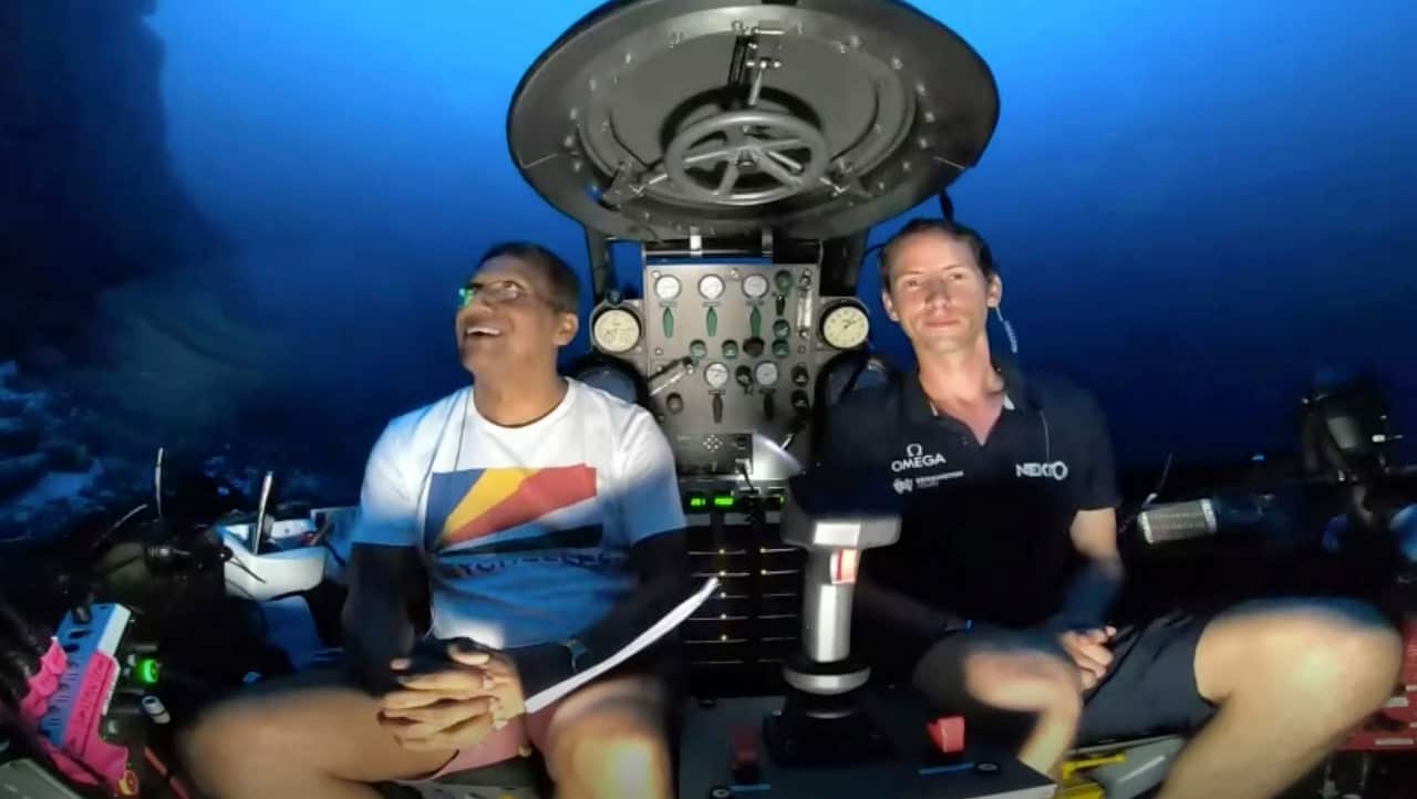 An image taken from video issued by Nekton shows Seychelles President Danny Faure, left, smiling after speaking from inside a submersible.